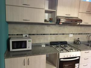 a kitchen with a microwave and a stove top oven at Cabañas Entre Pinos in Villa Gesell +91 photos