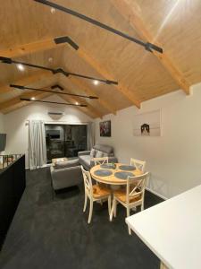 a living room with a table and chairs and a couch at Alex Apartment - 14A in Queenstown