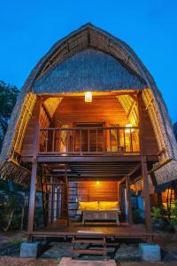 a large wooden house with a thatched roof at Sukanusa Luxury Huts in Nusa Lembongan