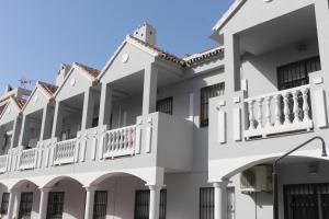 a row of white apartment buildings with balconies at Los Colimbos in Torremolinos