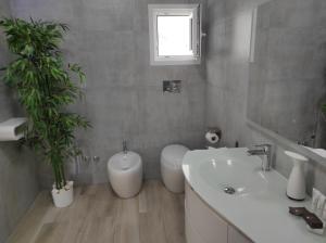a bathroom with a sink and a tub and two plants at Romantico open space Luna in Orosei