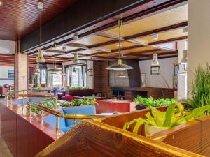 un restaurant avec des tables, des chaises et des plantes dans l'établissement Apartment on the lakeside in Hahnenkle, à Hahnenklee