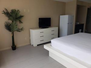 a bedroom with a bed and a tv and a palm tree at Unit 1005 at Sun N Sand Resort in Myrtle Beach