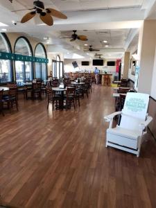 un restaurante con suelo de madera, mesas y sillas en Unit 1005 at Sun N Sand Resort, en Myrtle Beach