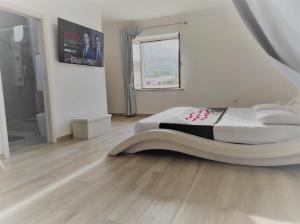 1 dormitorio con 1 cama grande y suelo de madera en Romantico open space Luna en Orosei