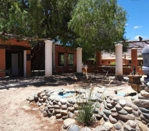 a backyard with a fountain and a building with columns at Finca El Carmen Cabañas in Angastaco