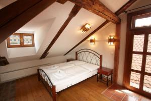 a bedroom with a white bed in a attic at Residence Muzeum Vltavínů in Český Krumlov