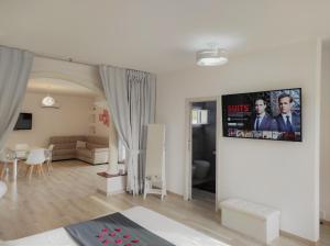 uma sala de estar com um sofá e uma televisão na parede em Romantico open space Luna em Orosei