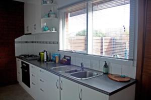 Una encimera de cocina con un fregadero y una ventana. en Garland Grove, en Ocean Grove