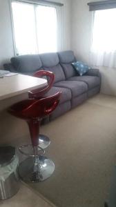 - un salon avec un canapé, une table et un tabouret dans l'établissement Te Puru B8 - 2 bedroom chalet, à Te Puru
