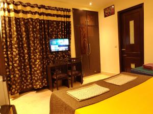 um quarto com uma cama e uma televisão em Pearl Premium Homes, Family BnB Guest-House em Nova Deli