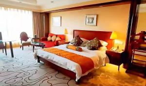 a hotel room with a large bed and a couch at Maritim Hotel Taicang Garden in Taicang
