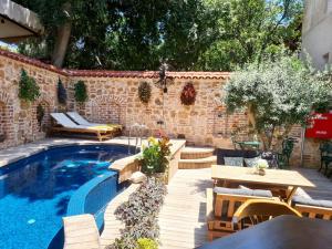 a backyard with a swimming pool and tables and chairs at Hotel Lykia Old Town Antalya in Antalya