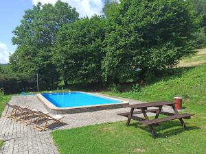 a swimming pool with two benches and a picnic table at Penzion Jizera Malá Skála in Malá Skála