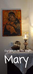 a painting on the wall next to a table with a lamp at Meteora Mary's mansion in Kalabaka