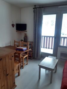 een woonkamer met een bank, een tafel en een televisie bij Les Terrasses du Mont blanc in Le Praz de Lys