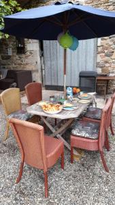 una mesa con platos de comida y una sombrilla en Carpe Diem Bed and Breakfast, en Beaulieu-sur-Dordogne
