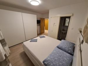 a bedroom with a bed with blue pillows on it at Apartment Markus in Makarska