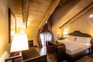 a bedroom with a bed and a desk with a lamp at Palazzo Righini in Fossano