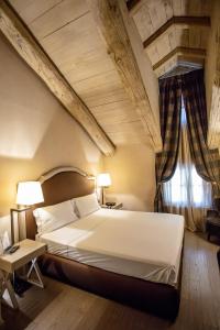 a hotel room with a bed and a night stand at Palazzo Righini in Fossano