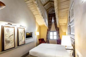 a hotel room with a bed and a tv at Palazzo Righini in Fossano