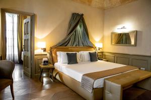 a hotel room with a large bed and a large window at Palazzo Righini in Fossano
