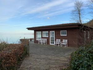 a small house with chairs in front of it at Loff Holiday Houses in Aabenraa