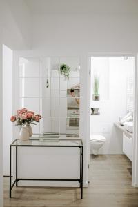 a bathroom with a glass table with flowers on it at SunsetView Apartment in Oradea +29 photos