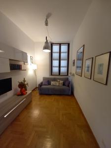 - un salon avec un canapé bleu et du parquet dans l'établissement Delizioso appartamento in corte, à Vittuone