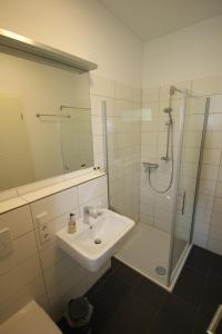 a white bathroom with a sink and a shower at Zimmervermietung am Habsberg in Velburg