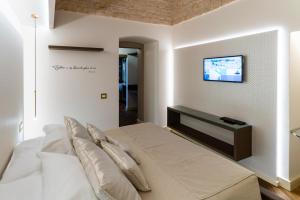 a bedroom with a bed with a tv on the wall at Palazzo Scotto in Alberobello
