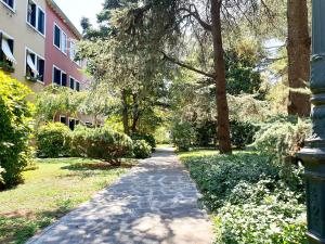 um caminho através de um parque com árvores e um edifício em Patch of Eden em Veneza