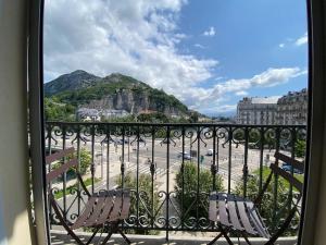 uma varanda com 2 cadeiras e vista para a cidade em Le Téléphérique, vue Bastille, 6 pers, 300 m Gare em Grenoble