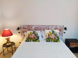 un letto con due cuscini e una lampada rossa di Masseria Baroni Nuovi a Brindisi