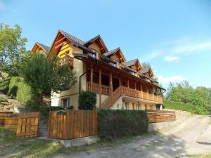 a house with a wooden fence in front of it at Noclegi ''U Wandy'' in Polańczyk