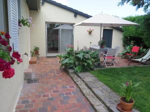 a patio with a table and an umbrella at chez Annick in La Flèche