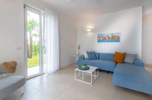 a living room with a blue couch and a table at Pareus Beach Resort in Caorle