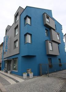 a blue building with windows on the side of it at Hotel Helada in Mladá Boleslav