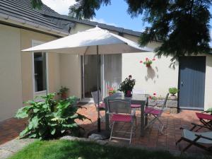 een patio met een tafel en een parasol bij chez Annick in La Flèche