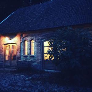 a brick house with a bench in front of it at night at Gladeholm - Kivik - artist studio in Kivik