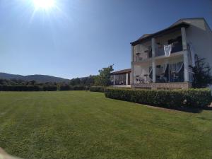 a white house sitting in the middle of a grassy area at Il Pagio in Alghero