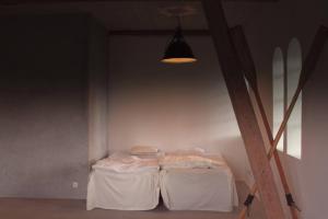 um quarto com uma cama com uma mesa e uma luz em Gladeholm - Kivik - artist studio em Kivik