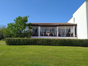 a white house with chairs and a yard at Il Pagio in Alghero