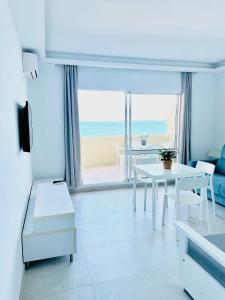 ein Wohnzimmer mit einem Tisch und Strandblick in der Unterkunft Benal Beach Sea View Apartment (Benalmadena) in Benalmádena