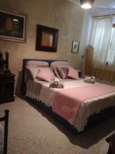 a bedroom with a large bed with pink pillows at La finestra sul mare in Budoni