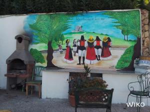 a mural of a group of people on a wall at La finestra sul mare in Budoni