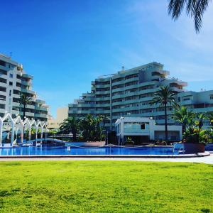 ein großes Gebäude mit Palmen vor einem Park in der Unterkunft Benal Beach Sea View Apartment (Benalmadena) in Benalmádena + 16 Fotos