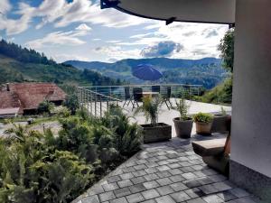 eine Terrasse mit einem Sonnenschirm und Bergblick in der Unterkunft Ferienwohnung Talblick in Schönau im Schwarzwald