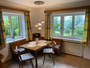 a dining room with a table and chairs and windows at Ferienwohnung Laimer, Radau 37 in St. Wolfgang
