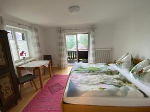 a bedroom with a large bed and a table at Ferienwohnung Laimer, Radau 37 in St. Wolfgang